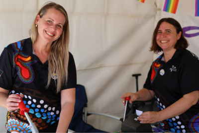 two people making badges smiling