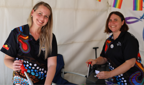 two people making badges smiling