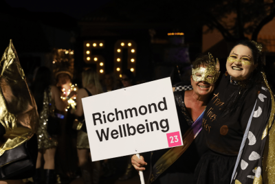 two people hugging, smiling and holding a name sign