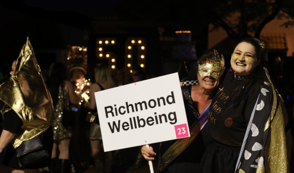 two people hugging, smiling and holding a name sign