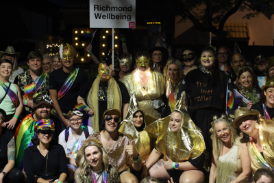 Large group of people in gold and rainbow outfits