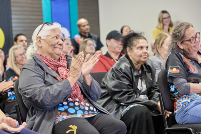 members of a crowd sitting and clapping