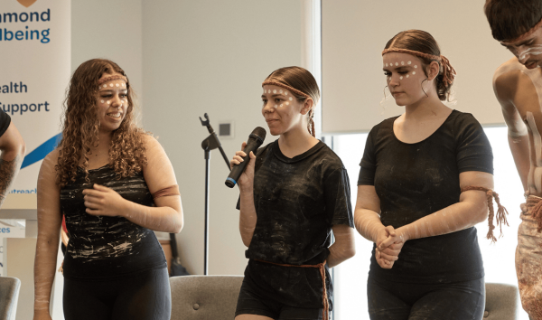 three girls speaking in traditional Aboriginal clothing