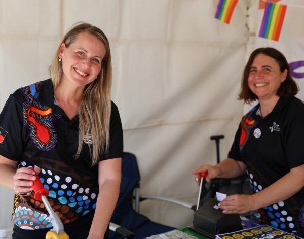 two people making badges smiling