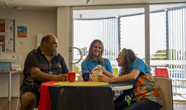 Three people sitting at a table laughing and smiling